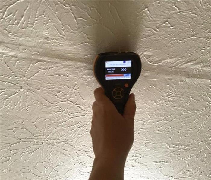 Moisture meter checking moisture content in ceiling